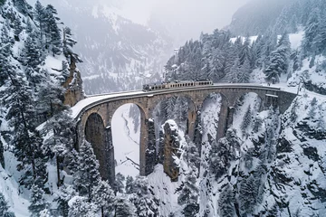 Photo sur Plexiglas Viaduc de Landwasser Majestic Journey Through the Swiss Alps  Aerial View of a Train Traversing the Landwasser Viaduct in Winter