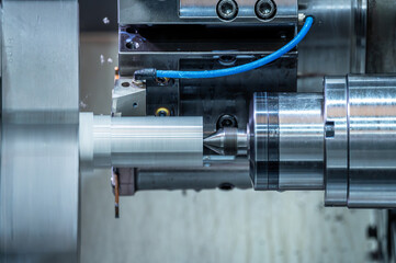 The CNC lathe machine forming cutting the metal parts. hi-technology metal working by CNC turning...