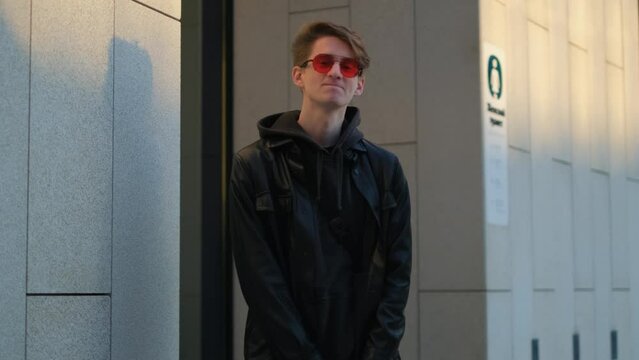 A young man waits unbearably at the entrance to a public toilet