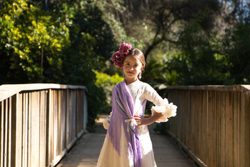 Portrait of a pretty girl dancing flamenco in a dress with frills and fringes typical of gypsies,...