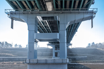 steel frame and concrete construction huge car bridge across the wide river. - obrazy, fototapety, plakaty