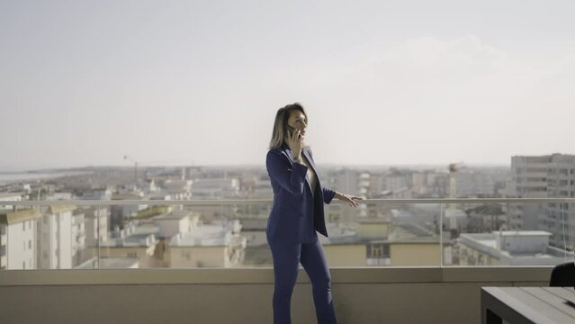 Donna parla al telefono fuori dall'ufficio