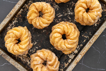 Honey cruller donuts on a baking tray