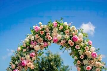 A wedding arch beautifully decorated with pink and white flowers in a stylish and elegant fashion.