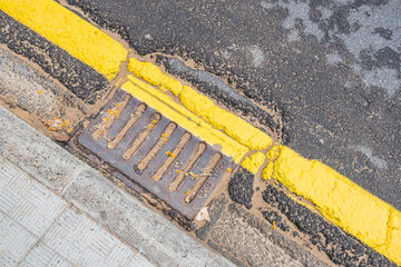 Fototapeta premium the old water drain is clogged with sand and the yellow line