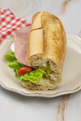 sandwich jambon cuit et crudités dans une assiette	