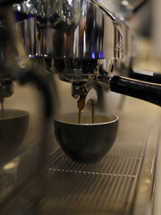 taza en la cafetera del restaurante llenándose de café para elaborar capuchino