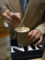 Fototapeta na wymiar barista experto elaborando café capuchino y decorándolo con crema y utensilios profesionales