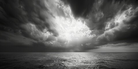 Black and white photo showing dramatic grey clouds hanging over the ocean