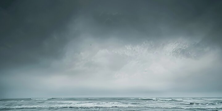 A vast body of water under a dramatic grey sky filled with clouds. Dramatic grey sky.