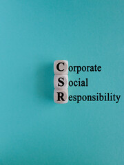 CSR Business and Corporate Concept, Corporate Social Responsibility and Giving Back to Community, CSR icon on wooden cubes. Beautiful blue background