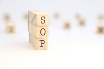 Acronym SOP (Standard Operating Procedure) isolated in wooden cubes on white background.