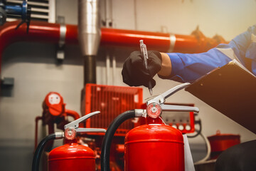 Engineer check fire extinguisher tank in the fire control room for safety in factory or industry.