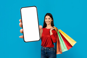 Woman Holding Blank Smartphone And Shopping Bags