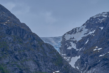 Blue Bondhusbreen Glacier hanging in the mountains over the Bondhusvatnet Lake and in Sundal, Vestland, Norway