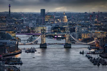 Photo sur Aluminium brossé Tower Bridge Elevated view of the illuminated Tower Bridge and St. Pauls Cathedral in London, England during a moody winter evening
