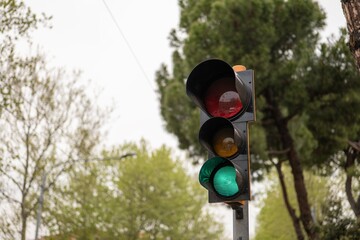 Traffic lights with green light on and trees in blurred background