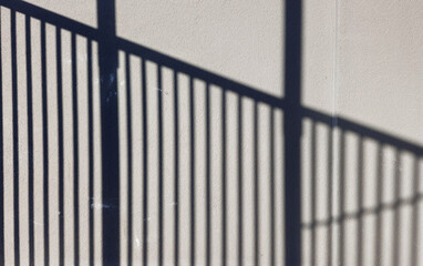 Shadow of Steel fence on the white wall in the one day afternoon.