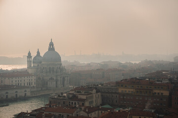 Misty day in Venice: View from San Marco Campanile captures Grand Canal, Basilica di Santa Maria della Salute, and foggy city skyline. - obrazy, fototapety, plakaty