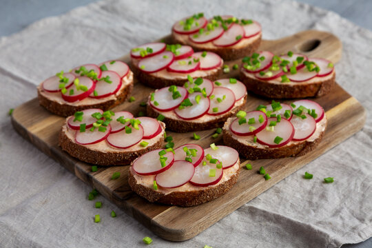 Homemade Lemon Radish Tartine on a wooden board, low angle view.