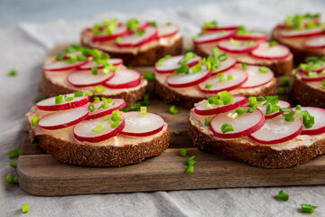 Homemade Lemon Radish Tartine on a wooden board, low angle view.
