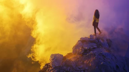 Foto op Plexiglas young woman standing on a rocky mountain outcropping with yellow smoke fills the background of the scene © pector