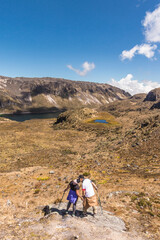 Couple of adult hikers kissing in front of the green lagoon in the Los Nevados National Natural Park in Colombia