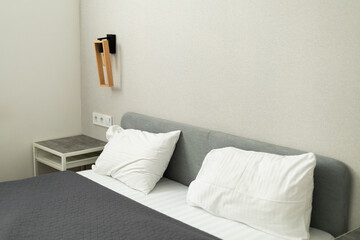 Fototapeta na wymiar headboard with white pillows and gray bedspread in the room