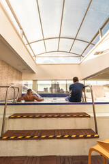 Vertical shot of two adult men in the pool of a hotel in the middle of the City of Pereira in Colombia