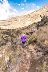 woman hikers walking through the paramo and rock formations of mountains of Los Nevados National Natural Park in Colombia