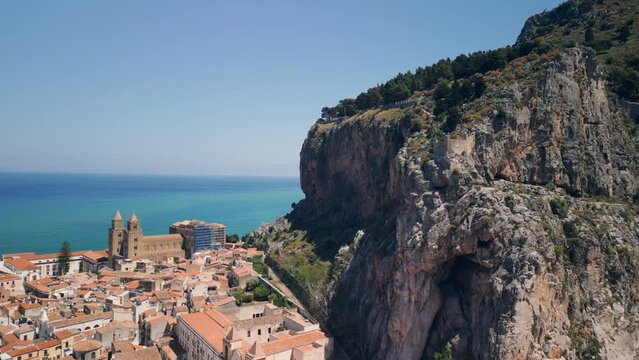 Aerial view of Cefalu, Sicily, Italy. Cinematic drone shot of famous travel destination. Slow drone shot in wide orbit. View of  Cefalu Cathedral and landscape