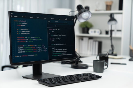 Programming code on computer screen desktop placing on working desk showing intelligent website development coder system running database online with information technology design concept. Infobahn.