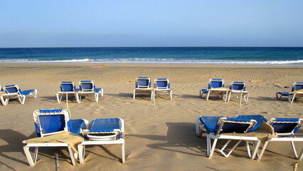 Empty blue loungers on the beach