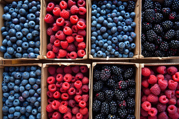 Blueberries and raspberries in baskets, for sale. Flat lay concept.