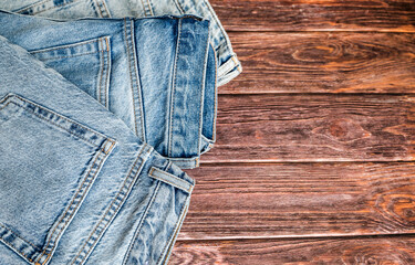 Blue jeans on a brown wooden background
