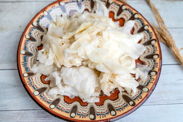 Homemade Sour Cabbage salad in a traditional Bulgarian plate. Fermented product. Sauerkraut 