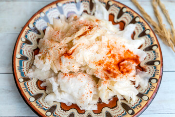Homemade Sour Cabbage salad in a traditional Bulgarian plate. Fermented product. Sauerkraut 