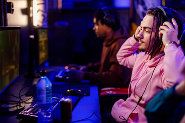 Fototapeta na wymiar Pro eSports male with dreadlocks gamer playing online strategy video game