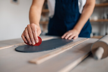 Close up of craftswoman's hands working with clay at ceramics studio.