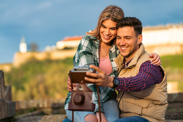 a young couple in love uses a vintage camera to immortalize their travels