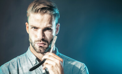 Hairdresser with straight razor for shaving. Tool for barber or shave. Unshaven man in casual wear...