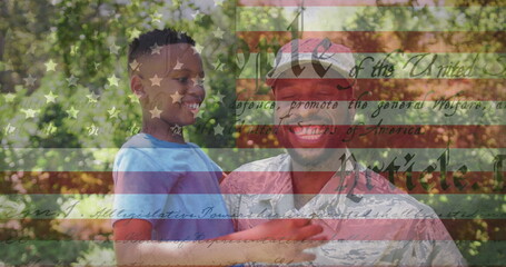 Image of male soldier embracing smiling son over american flag