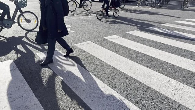 People cycling in Copenhagen, focus on bicycle shadows. 