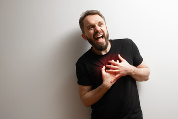 Heart health pain problem concept: man holds his heart area in pain