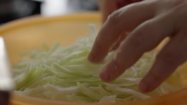 chopped white cabbage placed in a bowl, slow motion