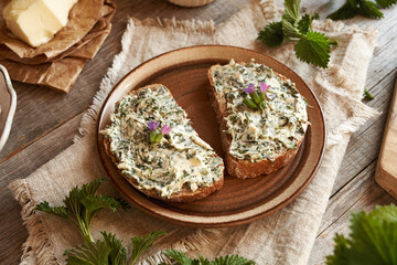 Nettle butter - homemade bread spread made of wild edible plants collected in spring, with fresh...