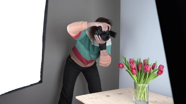Women photographer makes photos of tulips in the studio