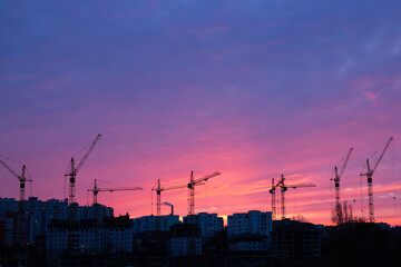 Progress and growth. Tower cranes on building of  many-storeyed house stock photo. Six tall...
