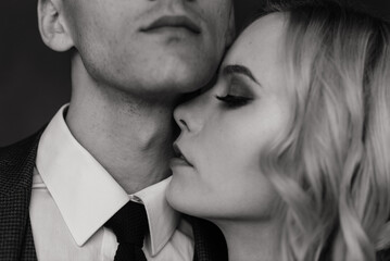 Cute wedding couple in the interior of a classic studio decorated. They kiss and hug each other.