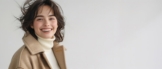 A stylish woman in a beige coat and white turtleneck.
